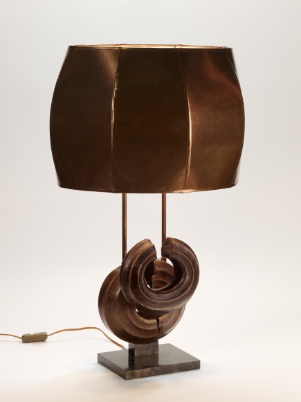 photograph of a brown lamp in a white room with two overlapping circles at its base