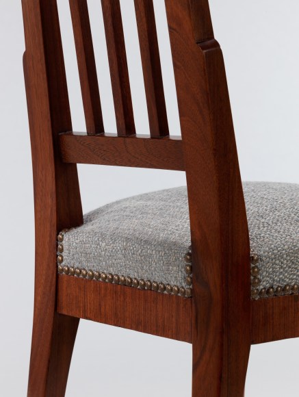 Detail of riveted upholstered seat meeting wood frame