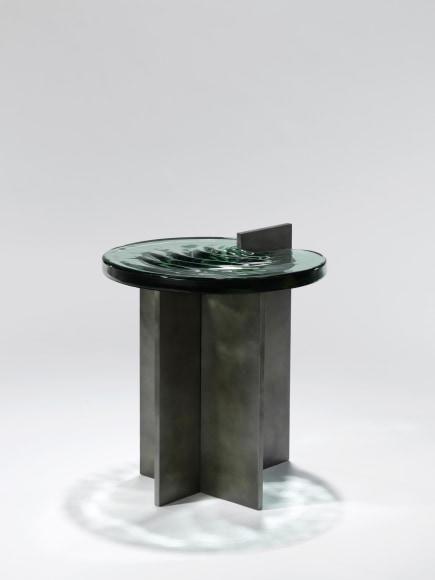 Madonna side table in aluminum and glass against a plain white background.
