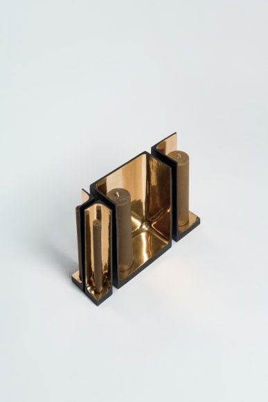 Bronze candlestick with gold detailing and black exterior.