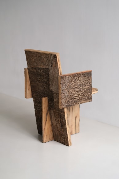 Wood and cork chair with arms and different angles photographed with a grey background.