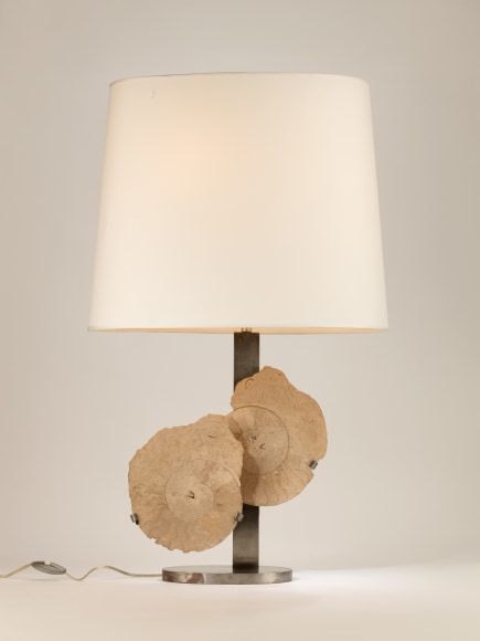 photograph of a lamp in a white room with two overlapping circles in the middle of its base