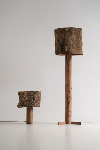 two lamps made of cork and oak against grey background.