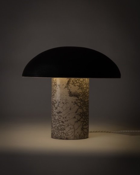 Illuminated lamp with a matte black glazed shade and white raku glazed base