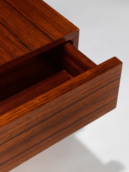 up close photograph of side table by Fermigier, tables have metal legs and teak tops