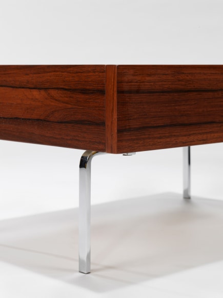 up close photograph of side table by Fermigier, tables have metal legs and teak tops