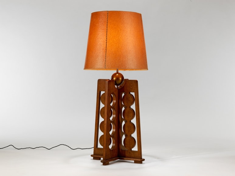 picture of a lamp with a wood base in a grey room