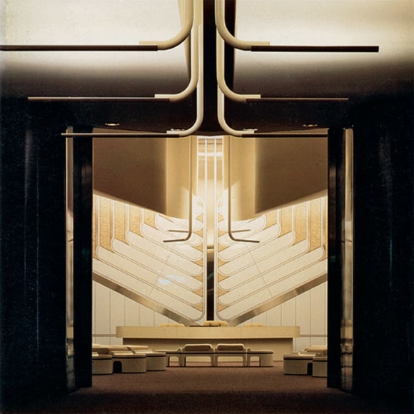 Archival photo of a large conference space with pipe-like lighting fixtures coming from the ceiling