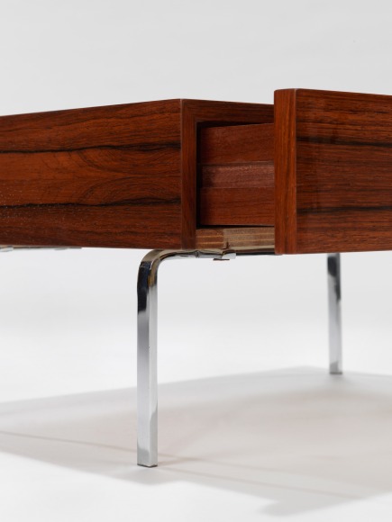 up close photograph of side table by Fermigier, tables have metal legs and teak tops