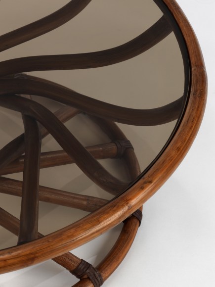 Smoked Glass top low table with curving stained woven bamboo structure in front of white background