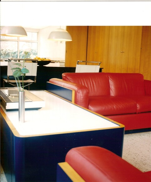 Archival photo of a living room designed by Philippon and Lecoq featuring a red love seat with a blue frame