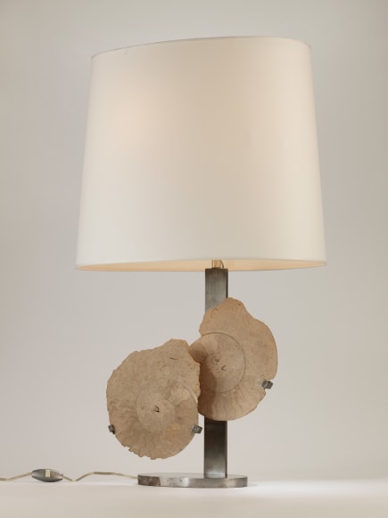photograph of a lamp in a white room with two overlapping circles in the middle of its base