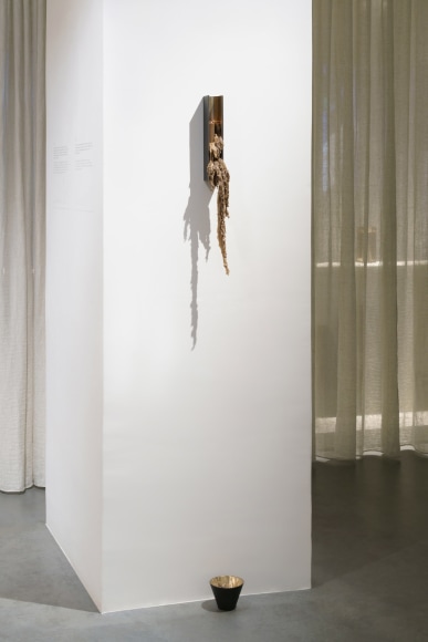 bronze with beeswax candle holder photographed on a grey background.