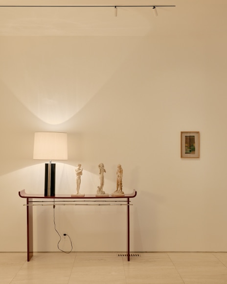 installation view of sheila hicks minime in the gallery beside a Maria Pergay red lacquer table.