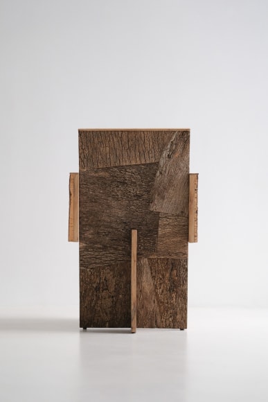 Wood and cork chair with arms and different angles photographed with a grey background.