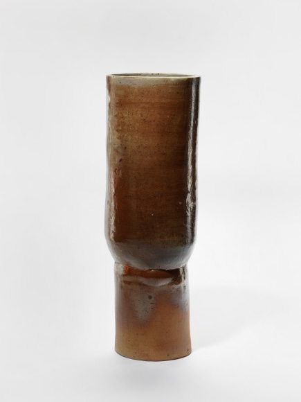 photograph of a cylindrical vase in an empty room