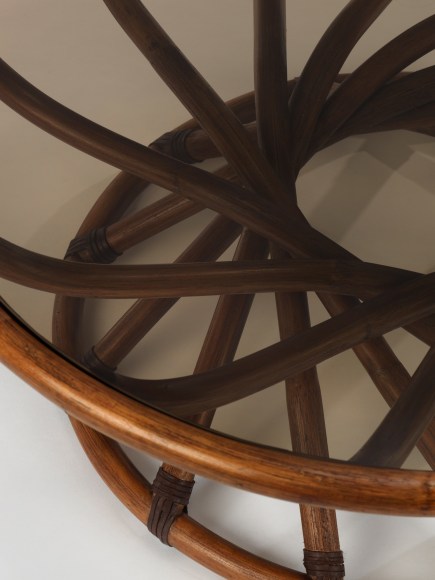 Smoked Glass top low table with curving stained woven bamboo structure in front of white background