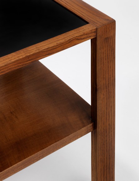 Detail of black opaline glass top and wood corner