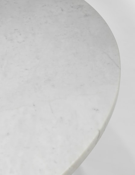 photograph of a table with steel legs and a marble top in a blank room