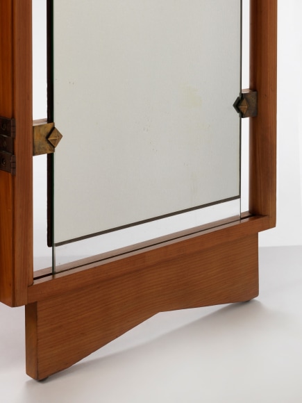 Detail of bottom of screen where brass hardware holds mirror