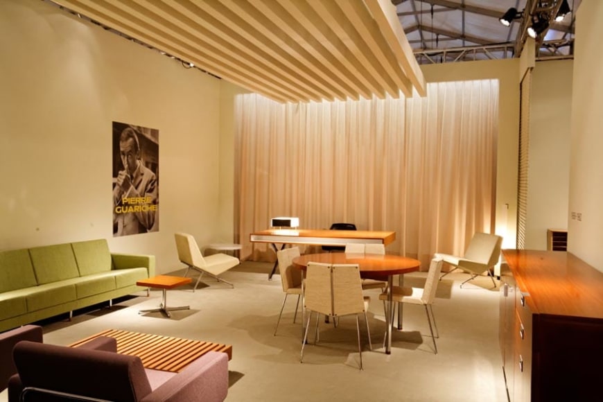 Installation view of Pierre guariche chairs in a booth.