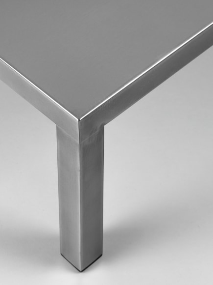 Stainless steel low table in front of white background