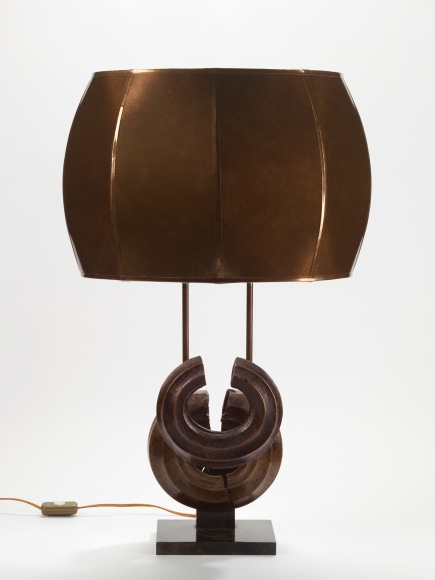 photograph of a brown lamp in a white room with two overlapping circles at its base