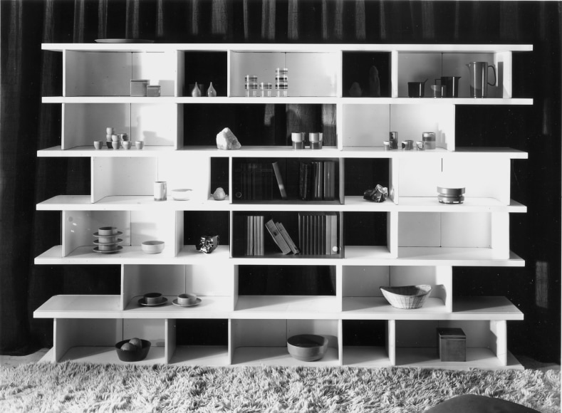 Black and white archival photo of Ren&eacute;-Jean Caillette's Modular Bookcase, 1970 filled with various books, cups, objects, and bowls