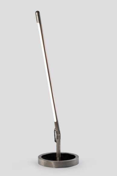 photograph of long metal floor lamp in a blank room