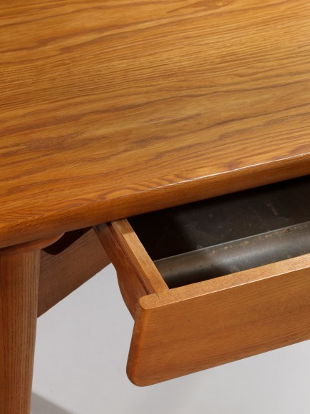 photograph of a wood desk in a blank room
