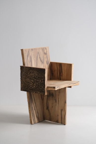 Wood and cork chair with arms and different angles photographed with a grey background.