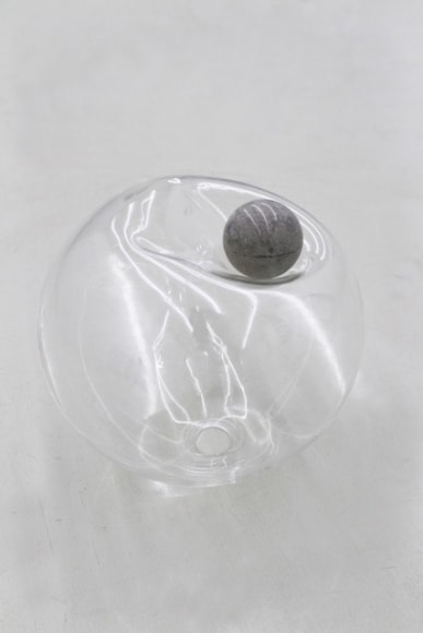 photograph of an amorphous glass sphere and concrete ball