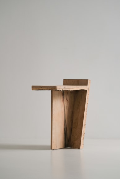 Side table made of oak and cork with a slant and photographed on grey background.