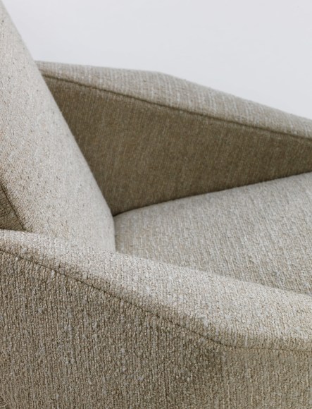 Detail of individual upholstered cream seat with detachable arms