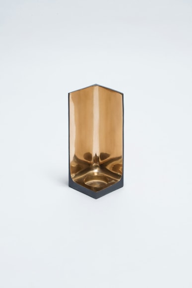 Bronze candlestick with gold detailing and black exterior.