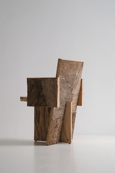 Wood and cork chair with arms and different angles photographed with a grey background.