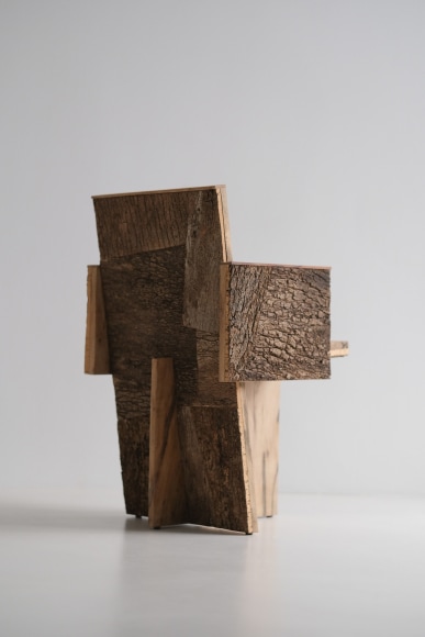 Wood and cork chair with arms and different angles photographed with a grey background.