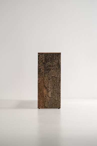 Bookshelf made of oak and cork standing against a grey background.