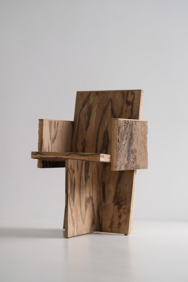 Wood and cork chair with arms and different angles photographed with a grey background.