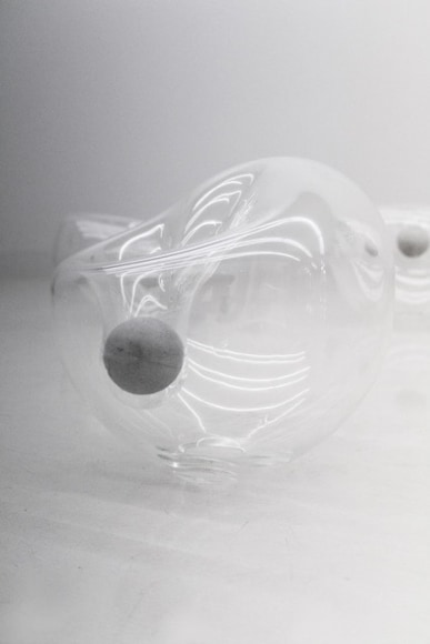 photograph of an amorphous glass sphere and concrete ball