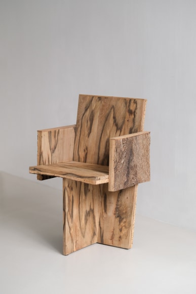 Wood and cork chair with arms and different angles photographed with a grey background.