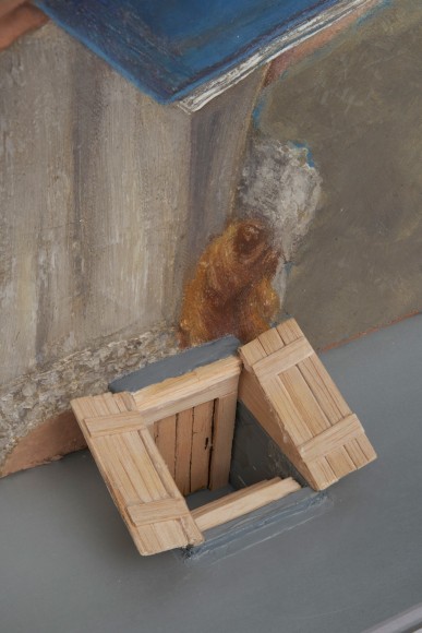 Robert Gober art work of a girl hanging upside down and reading with a branch and aluminum frame.