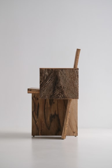 Wood and cork chair with arms and different angles photographed with a grey background.