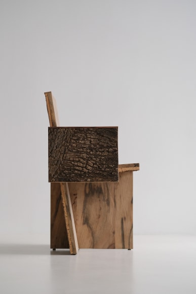 Wood and cork chair with arms and different angles photographed with a grey background.