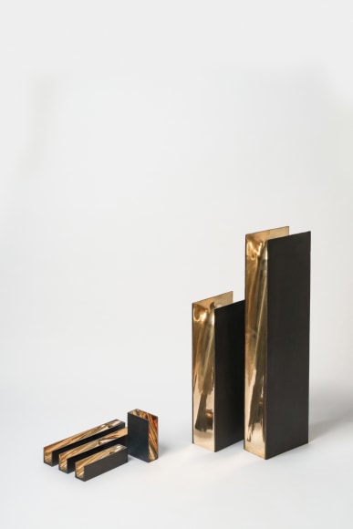 bronze with beeswax candle holder photographed on a grey background.