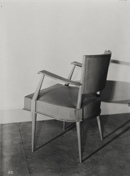 Black and white archival image of the chair made by Dumond facing away from us.