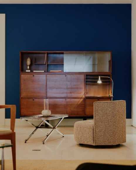 Installation view of works in the gallery, mostly furniture and some rugs and art. Big cabinet.