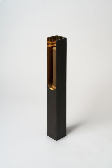 Bronze candlestick with gold detailing and black exterior.