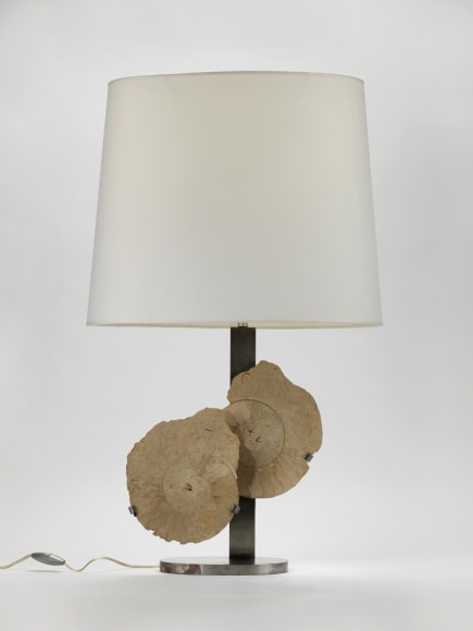 photograph of a lamp in a white room with two overlapping circles in the middle of its base