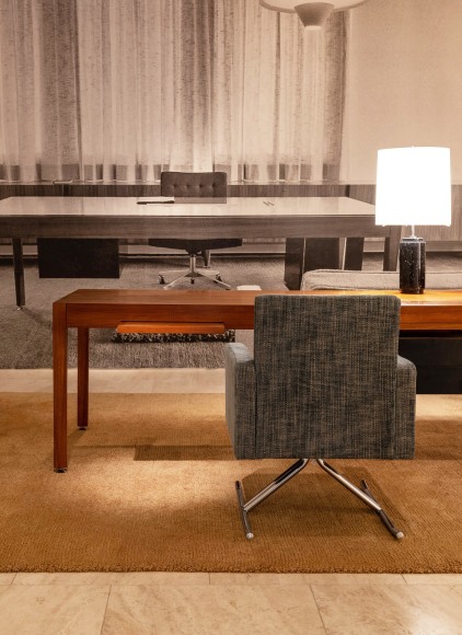 Installation view of Dunkirk Seaport archival image above Joseph-André Motte, Desk, 1965 and Pair of Luge Chairs, 1966. Photo by Ori Harpaz